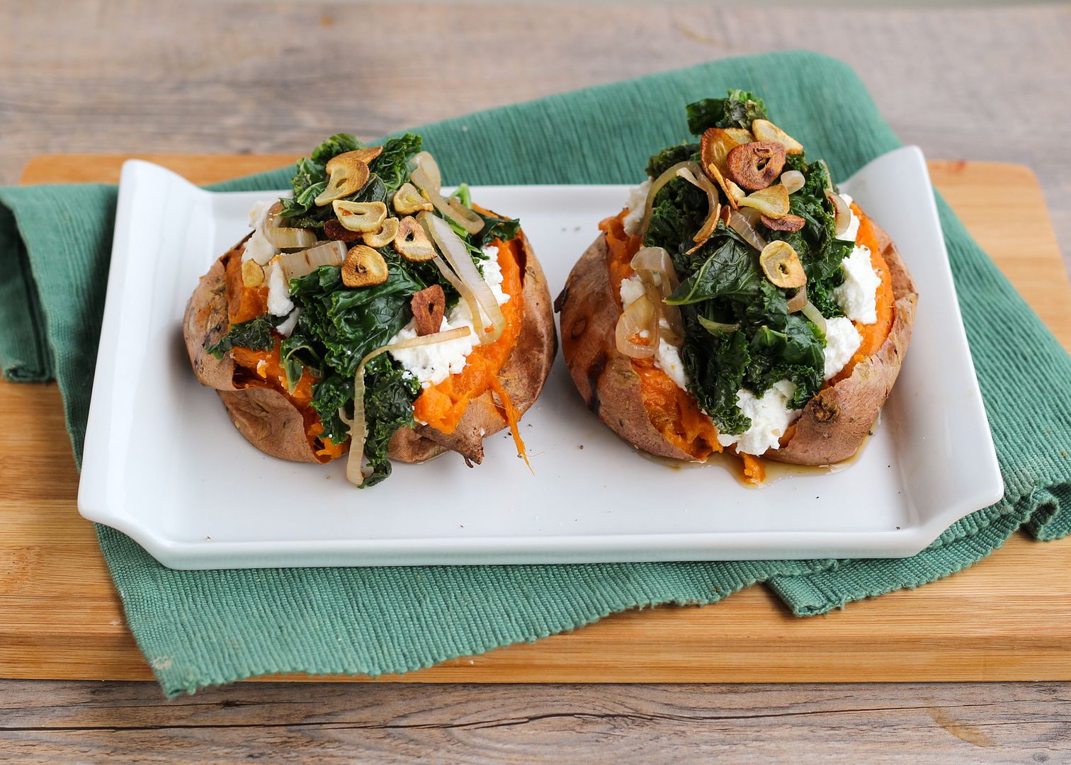 Baked Sweet Potatoes Topped with Ricotta, Goat Cheese, Kale, and Garlic Chips